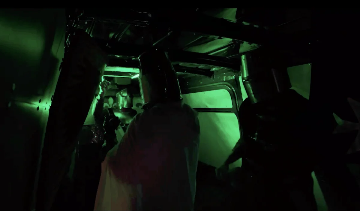 Scène filmée en vision nocturne verte à l'intérieur d'un van, live show Sainte Rave Party.